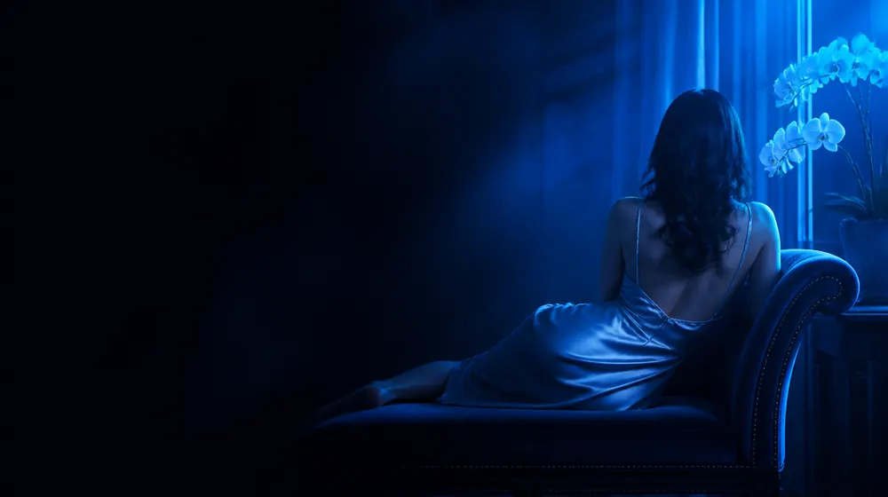 Pussy OnlyFans creators — woman in a silk slip dress reclining on a chaise longue, orchids blooming in the bedside vase