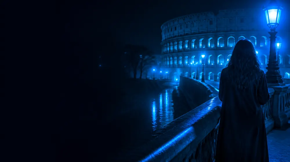 Rome OnlyFans creators — woman on a stone canal bridge with lantern glow, the Colosseum arches floodlit across the piazza