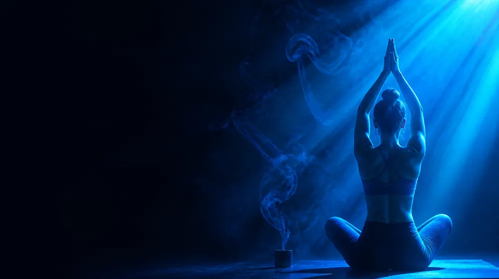 Tantra OnlyFans creators — woman in a yoga pose crossed by soft light beams, incense smoke curling through the beam