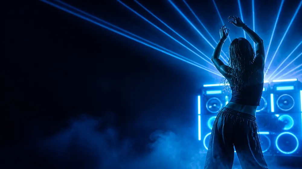 Twerking OnlyFans creators — woman dancing under sweeping laser beams, a boombox stack pulsing with light